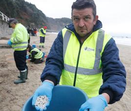 Playa de Aguilar. Un operario de las brigadas de limpieza muestra los pélets que ha recogido.