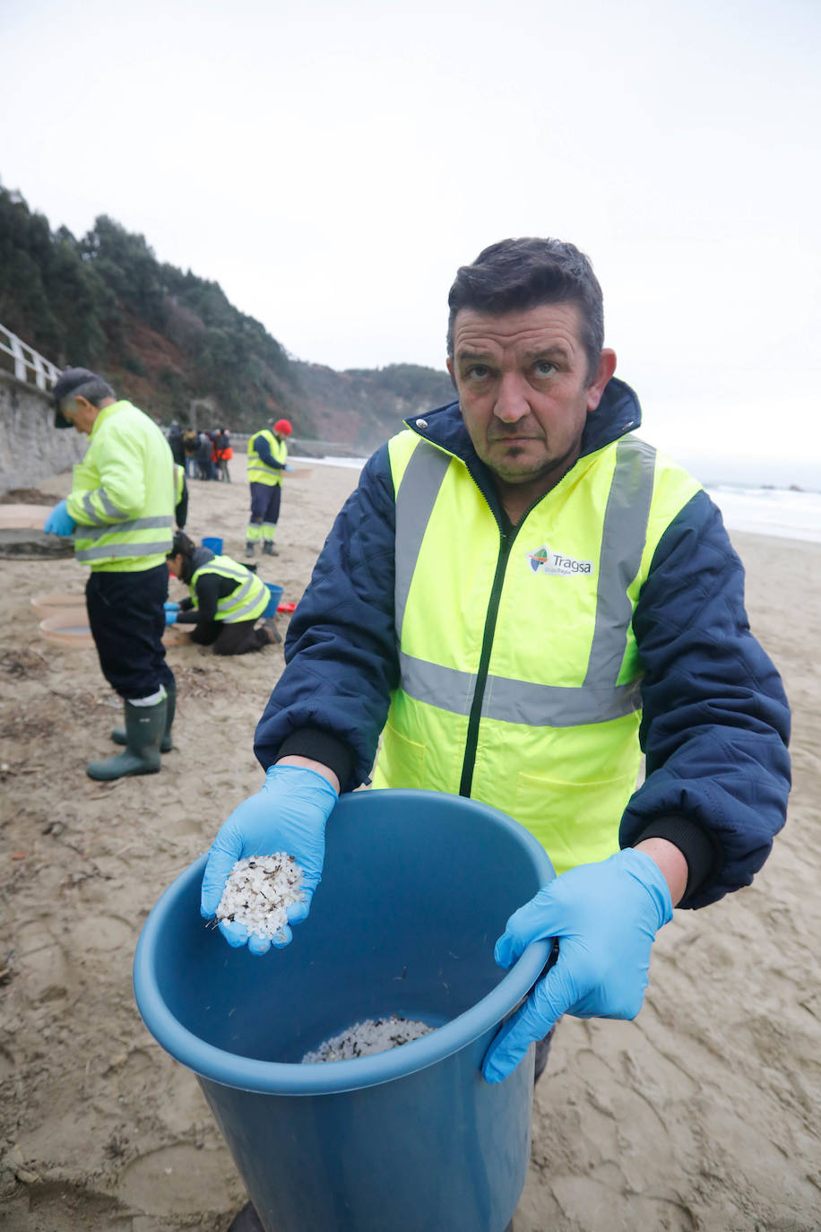 Playa de Aguilar. Un operario de las brigadas de limpieza muestra los pélets que ha recogido.