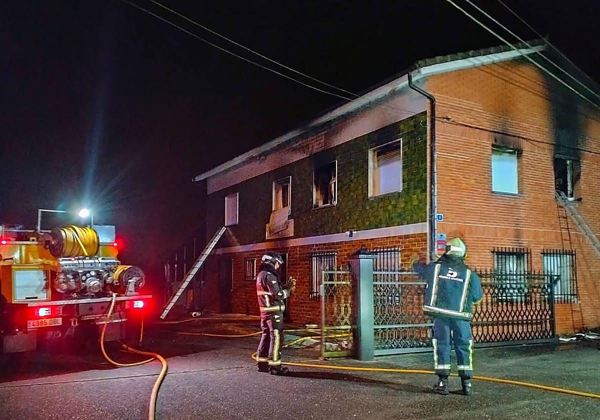 Los bomberos, durante las labores de extinción de un incendio en una vivienda en Nava.