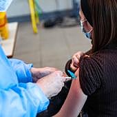 Una mujer recibe una vacuna en Gijón.