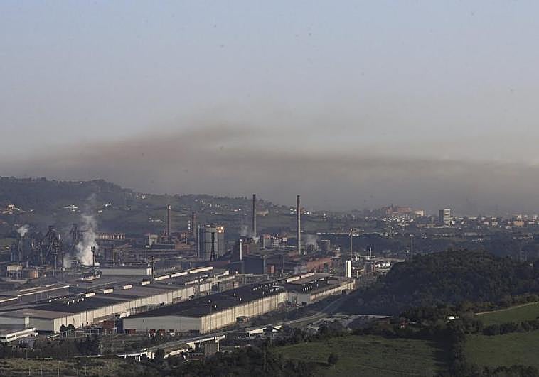 Boina de contaminación que era visible ayer por la mañana sobre Gijón, con la industria en primer término. En el vídeo, la protesta en el centro de salud de El Llano en protesta contra la contaminación con manifestantes hablando con la consejera de Salud Concepción Saavedra.