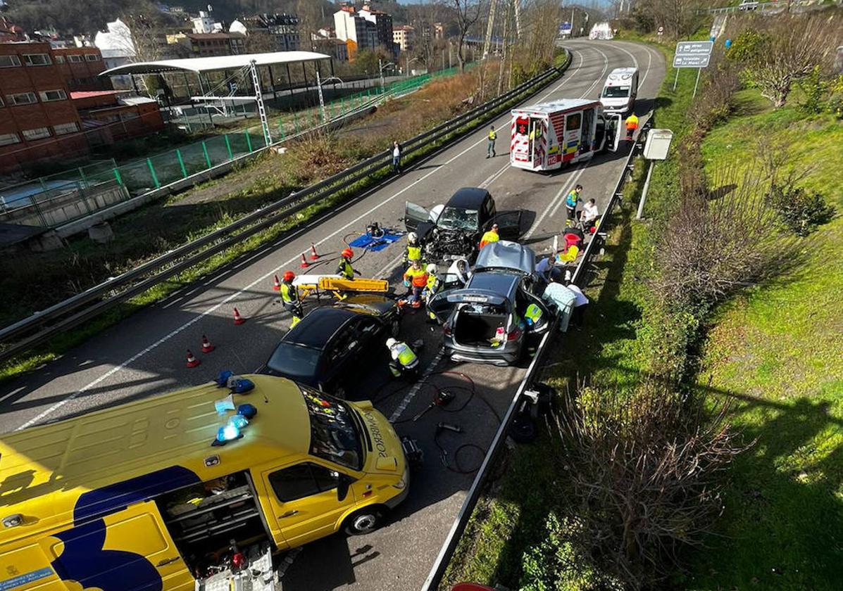 Sanitarios y bomberos en el lugar donde se produjo el brutal accidente del corredor del Nalón en el que murieron dos personas.