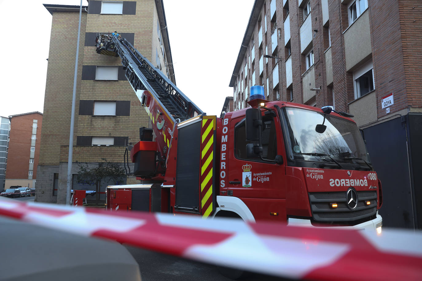 Maniobra de los bomberos de Gijón para sacar a una mujer inconsciente por la ventana