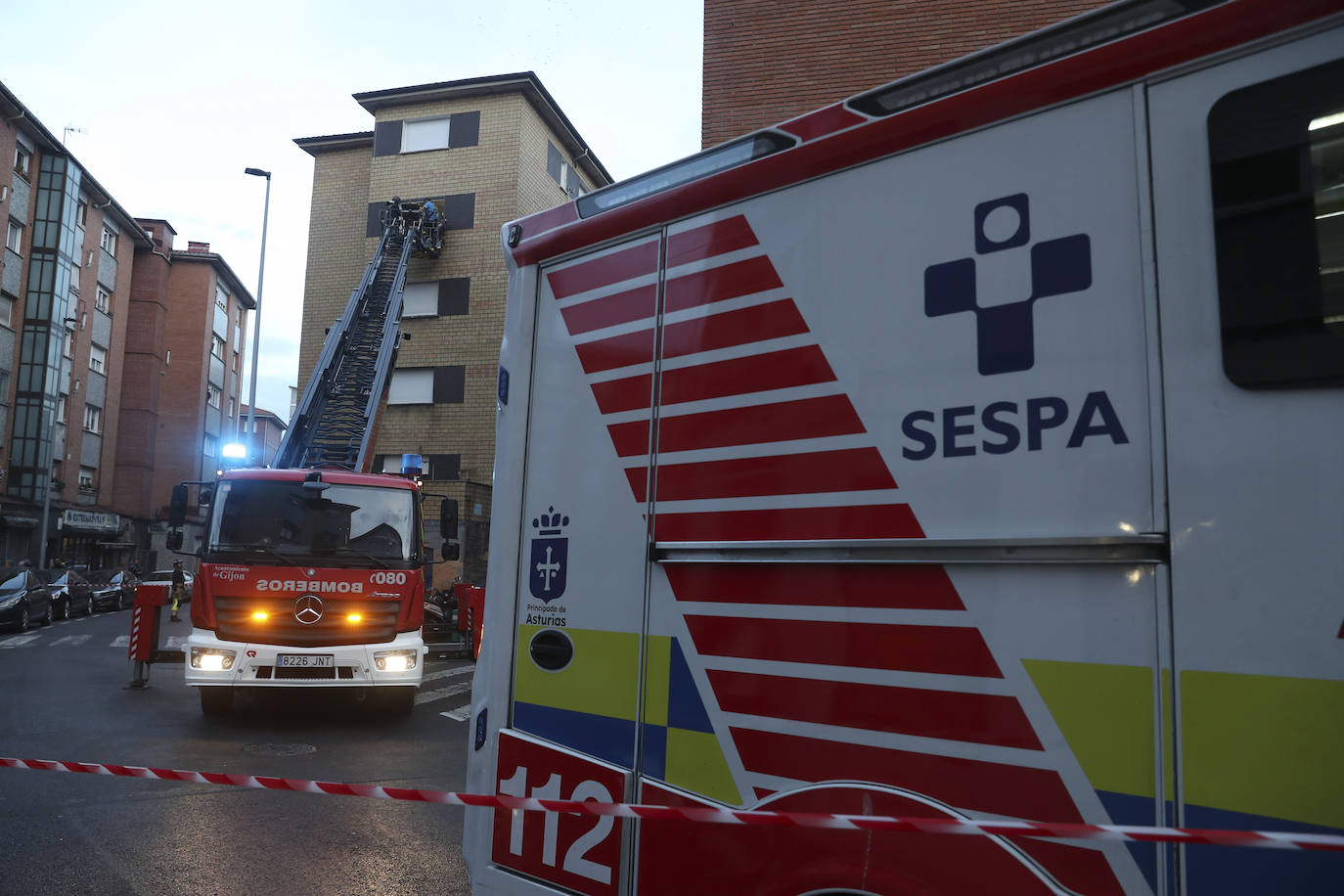 Maniobra de los bomberos de Gijón para sacar a una mujer inconsciente por la ventana