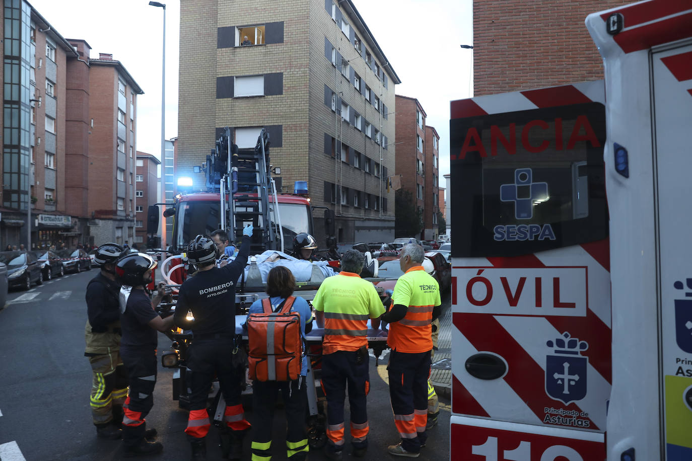 Maniobra de los bomberos de Gijón para sacar a una mujer inconsciente por la ventana