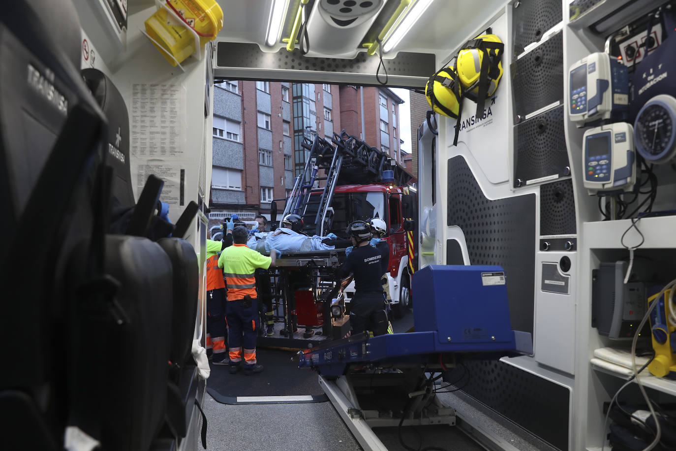 Maniobra de los bomberos de Gijón para sacar a una mujer inconsciente por la ventana