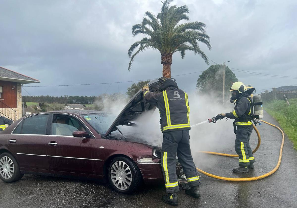 Dos bomberos trabajan en la extinción del fuego.