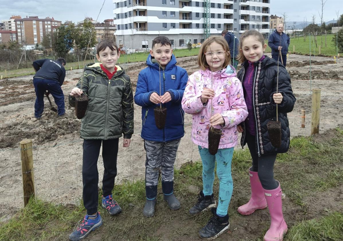 Lucas Cabo, Álex Montes, Carla Felgueroso y Mara Friera, alumnos de 3º de Primaria, posan con plantones de especies autóctonas.