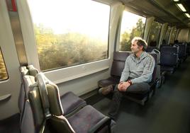 Carlos García, portavoz de Asturias al Tren, colectivo que suma 12 años reclamando la supresión de paradas en los apeaderos con menos usuarios, viajando en un tren de la línea Oviedo-San Esteban.