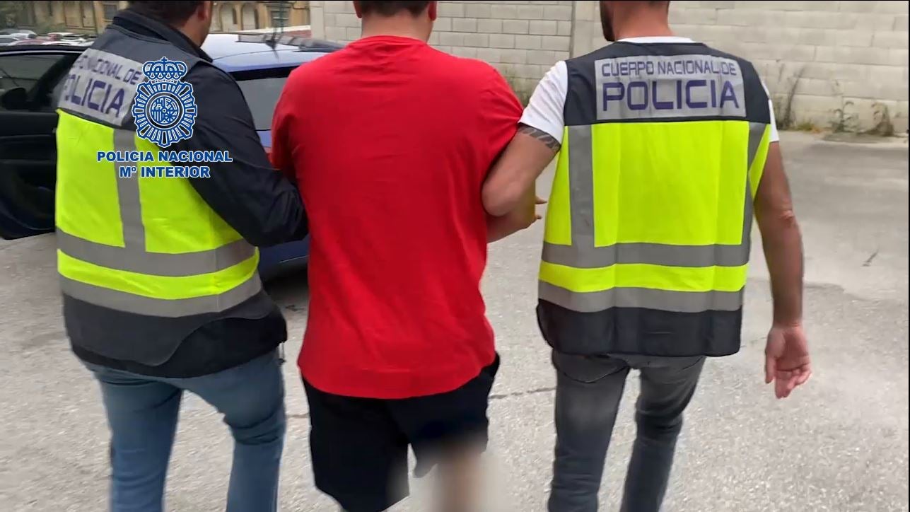 Dos policías nacionales trasladan al detenido al juzgado.