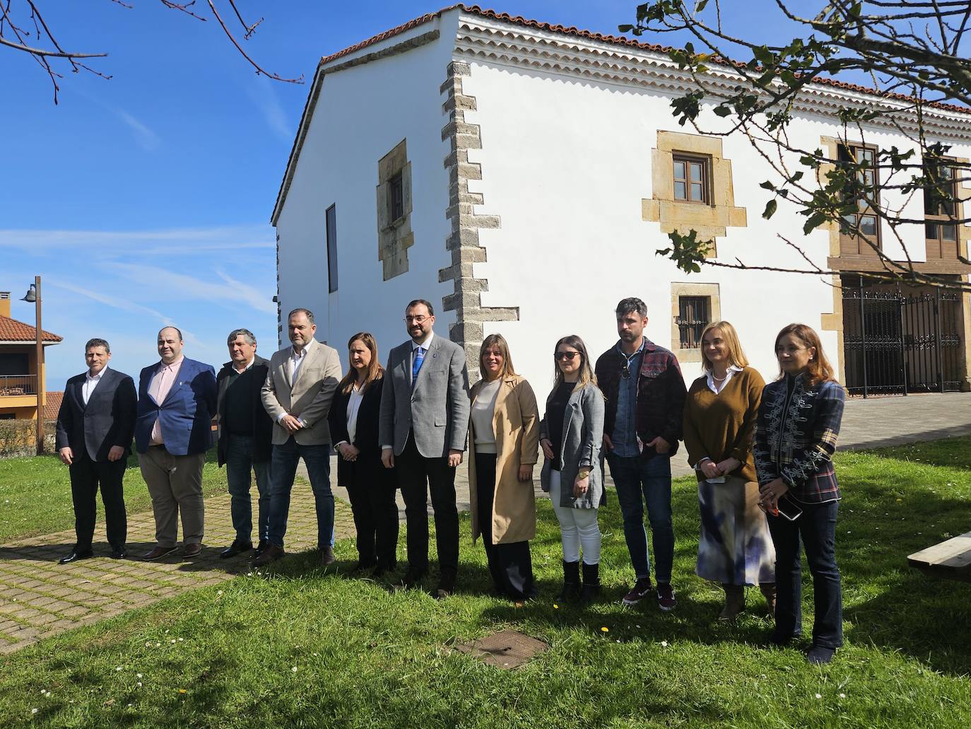 El presidente del Principado, Adrián Barbón, y la vicepresidenta, Gimena Llamedo, con la corporación municipal de Caravia y los responsables de la Cámara de Comercio de Oviedo.