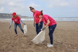 Claudia Alonso, en el centro de la imagen, junto a su compañera en el Adba Sanfer Marta Gómez y Eva Cuetos ayer recogiendo residuos.