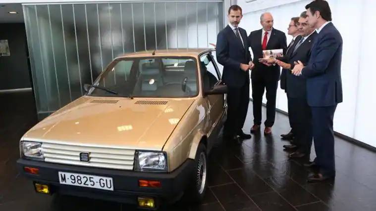 Don Felipe observa su primer coche, un Seat Ibiza SXI, que estuvo guardado en el museo de la marca en Barelona.