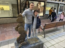 Miguel Linares y su hijo posan en la escultura que conmemora la fundación del Oviedo.