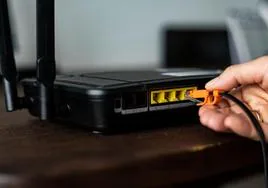 Un hombre conectando un cable de ADSL.
