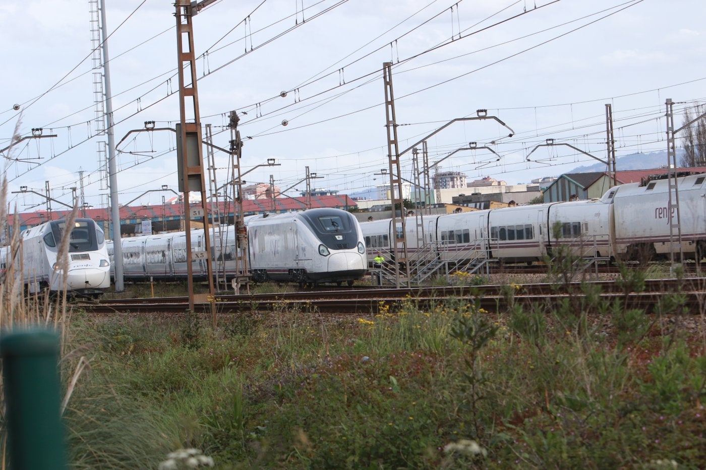 Un tren Avril, con la librea de AVE en su lateral, estacionado en La Calzada, entre dos unidades S-130 que prestan el servicio Alvia.