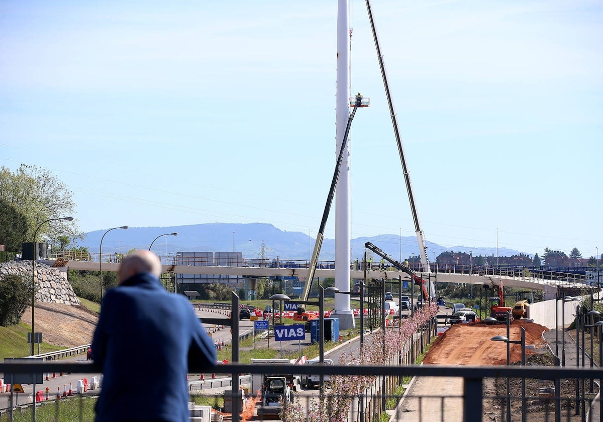 Un hombre observa desde el puente la colocación de los tirantes en el mástil.