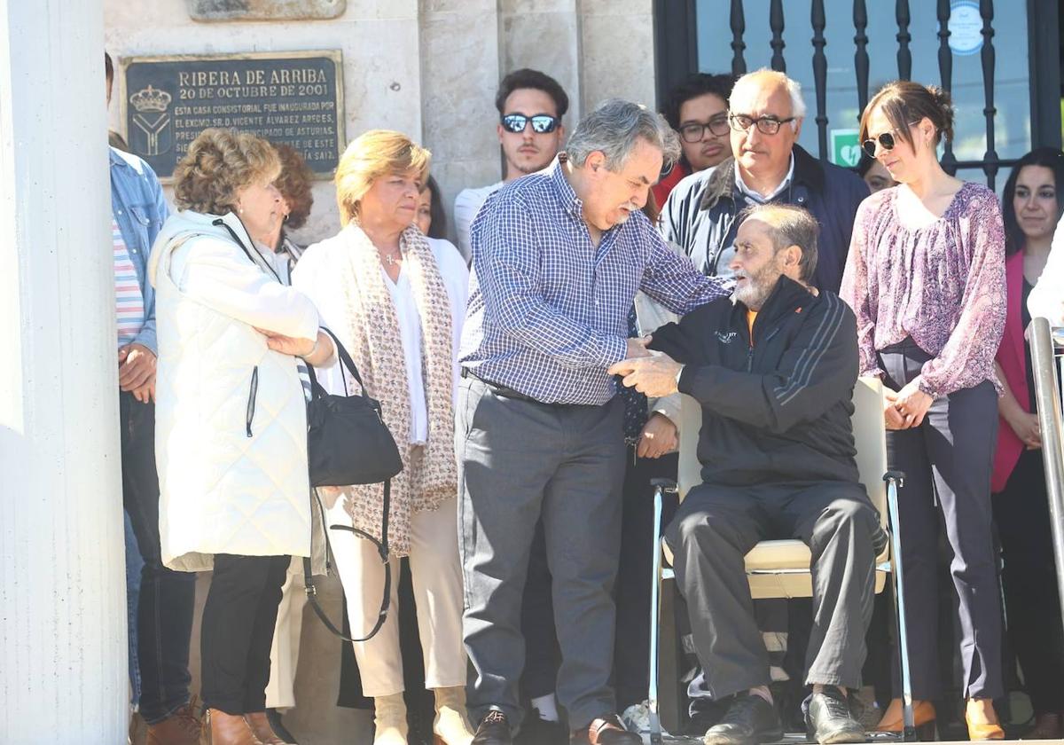 La familia de la víctima, Miguel Ángel Muñiz, durante el minuto de silencio en Ribera de Arriba al que acudieron numerosos vecinos.