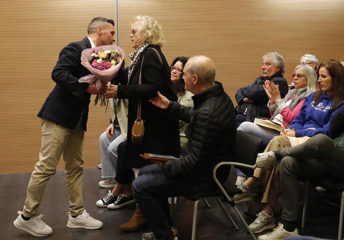 Víctor Crespo, presidente del Pielgo Team, entrega un ramo de flores a la madre de Alejandro, María Victoria González, en presencia del padre, José María Carnicero.