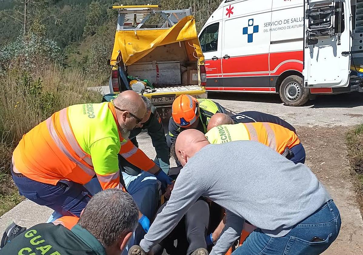 Guardia Civil, bomberos y sanitarios trasladan al ciclista herido a la ambulancia.