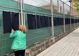Colocación de los trapos negros alrededor del campo de fútbol de Lloreda, en Tremañes.