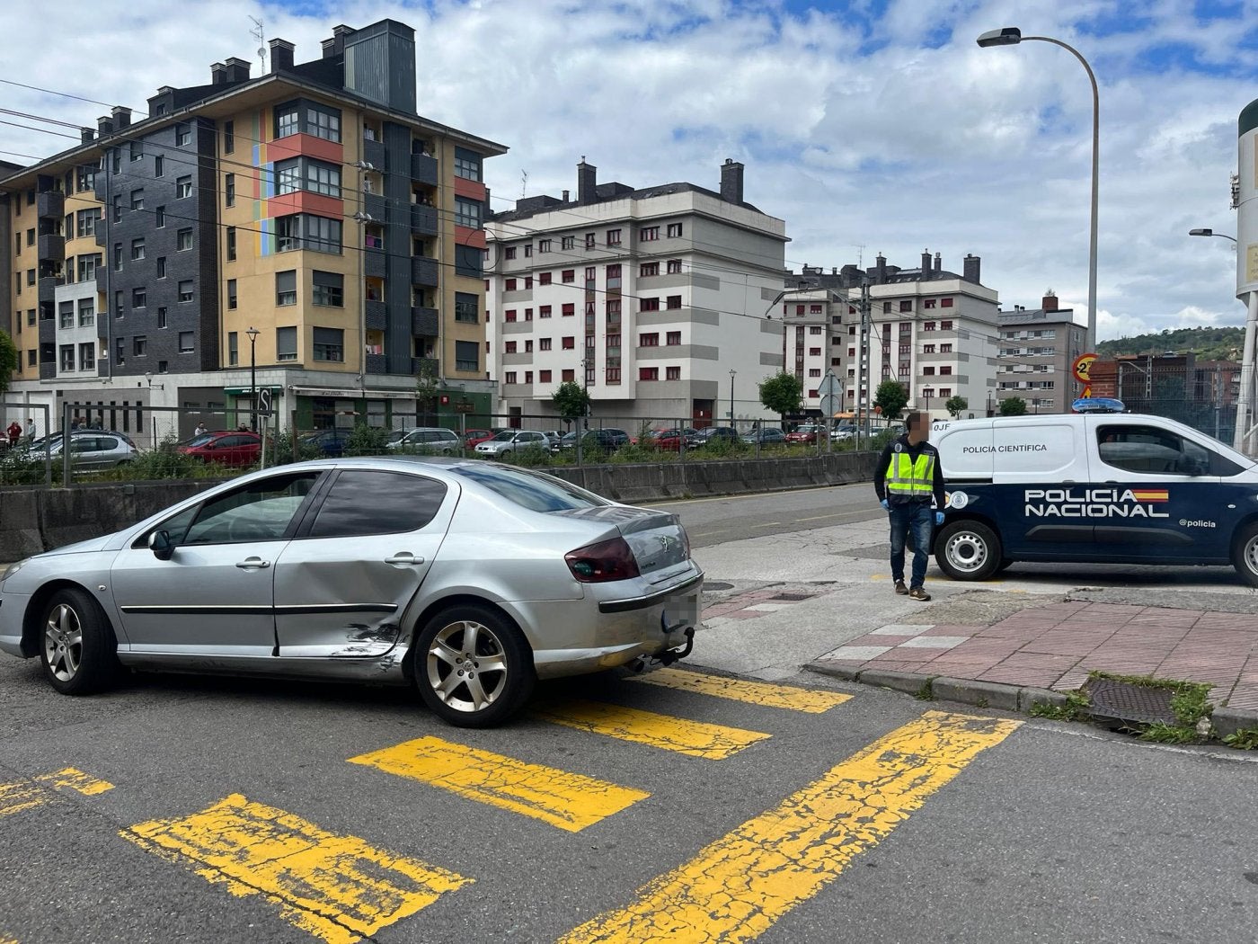 El coche en el que iba el matrimonio atacado, con el golpe en la puerta trasera, en la carretera de Valnalón con el cruce de la Pajomal.