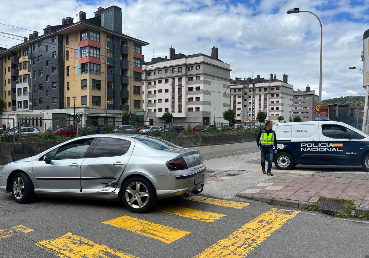 En primer término, el coche de la víctima. Tras él un agente de la Policía Nacional, en el lugar en el que se produjo el suceso.