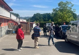 La propietaria del inmueble y casera de los sospechosos conversa con los agentes de la Policía Nacional, junto al jardín.