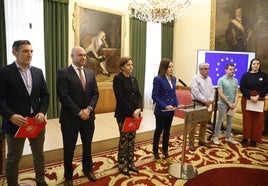 La alcaldesa, Carmen Moriyón, junto a los representantes de los grupos políticos municipales y Laura González, responsable de la Oficina de Relaciones Internacionales en el atril.