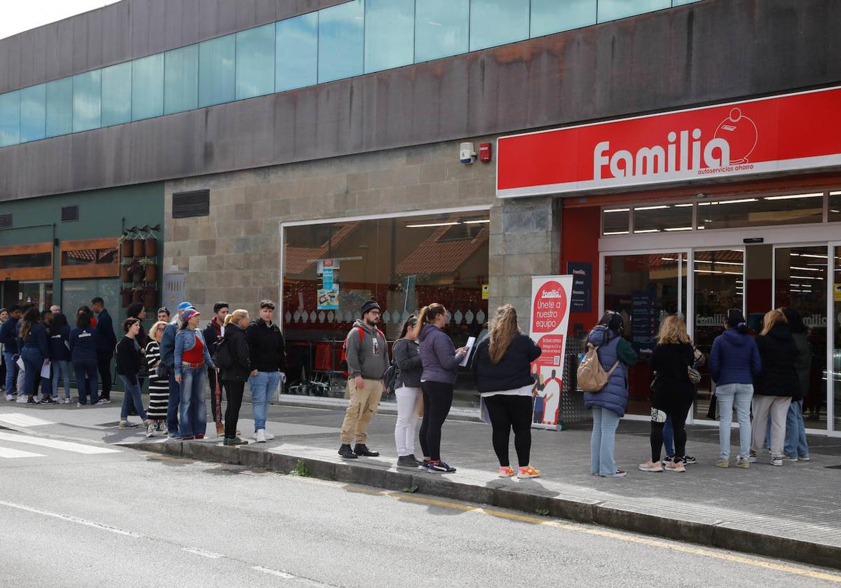 Personas hacen cola para entregar sus currículums para el proceso de selección Supermercados Familia en Asturias.