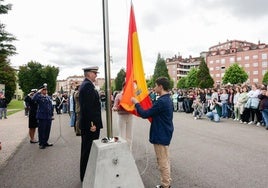 Los alumnos Ainara Hernantes y Pablo Torres fueron los encargados de izar la bandera de España en el patio del centro.