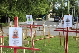 Representación de las 'muertes' laborales de los trabajadores de Sekurit, con cruces y fotografías plantadas frente a la entrada de la fábrica.