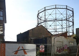 El cartel de Hercal, la empresa que acomete los derribos, con el gasómetro de fondo.