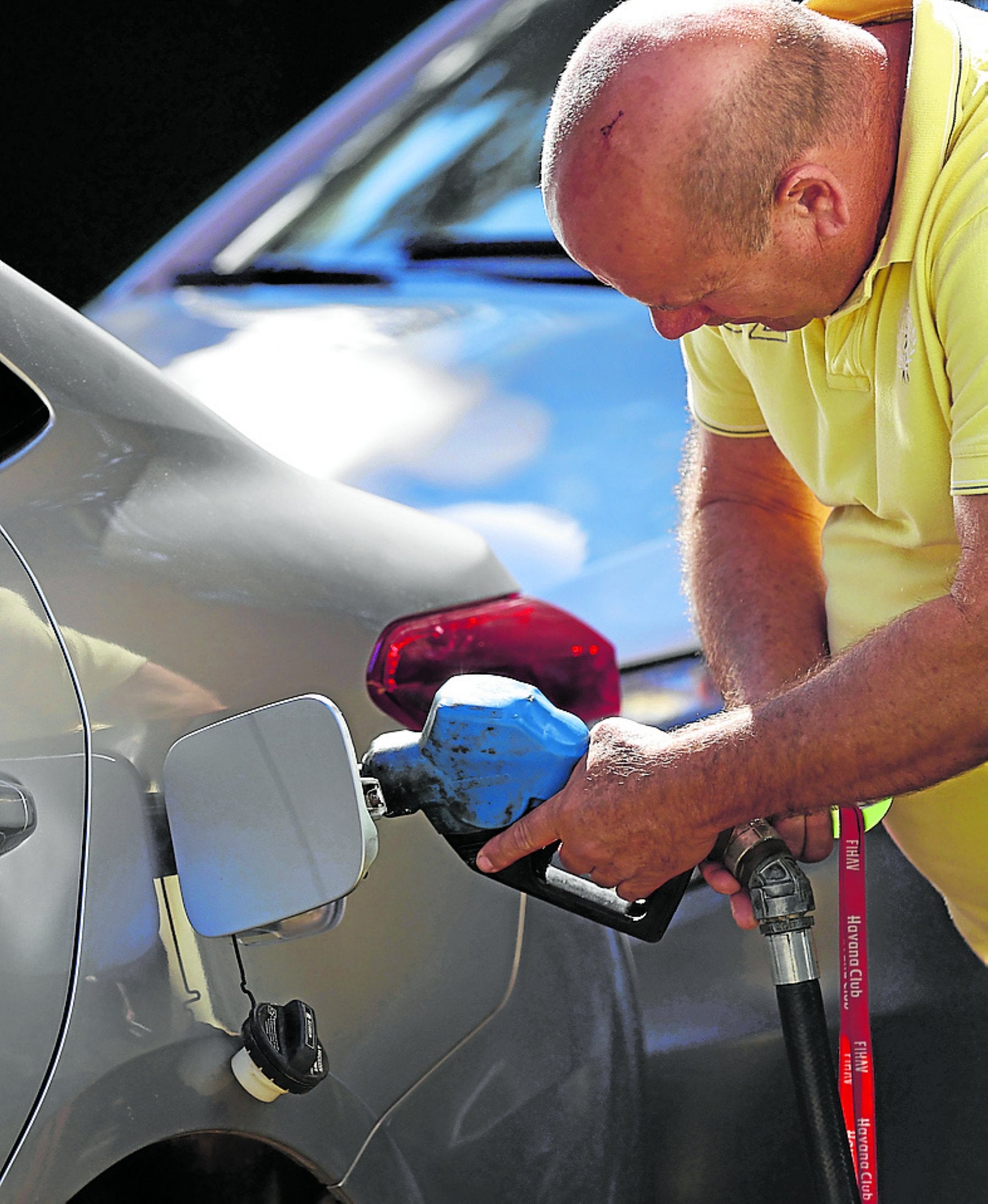 Un hombre echa gasolina en su vehículo.