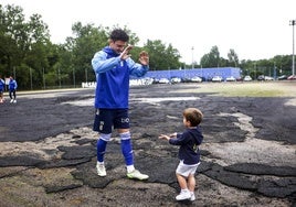 Borja Sánchez saluda a un pequeño aficionado del Oviedo antes del entrenamiento de este domingo.