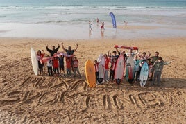 Miembros de las escuelas Skool Surf y Siroko Surf, junto al lema 'Puxa Sporting', en la playa de San Lorenzo.