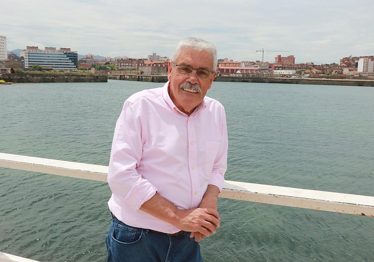 Floro apoyado en la barandilla de Poniente con los terrenos de Naval Gijón a sus espaldas.