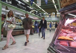 Clientes comprando en los puestos del mercado del Fontán.