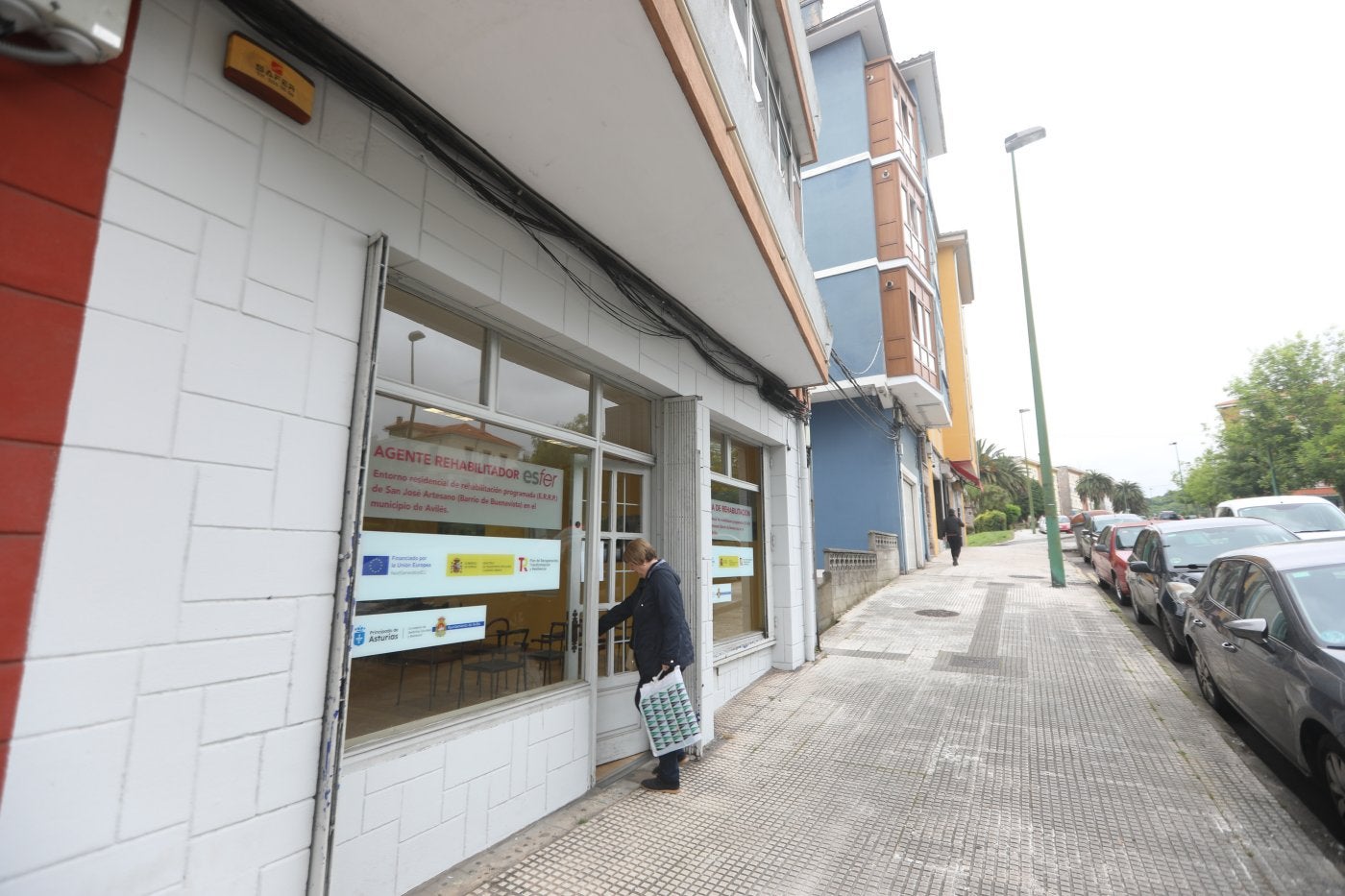 Una vecina entra en la oficina que el agente rehabilitado Esfer ha abierto en la calle Río San Martín.