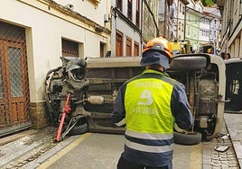 Un bombero, frente al vehículo accidentado.