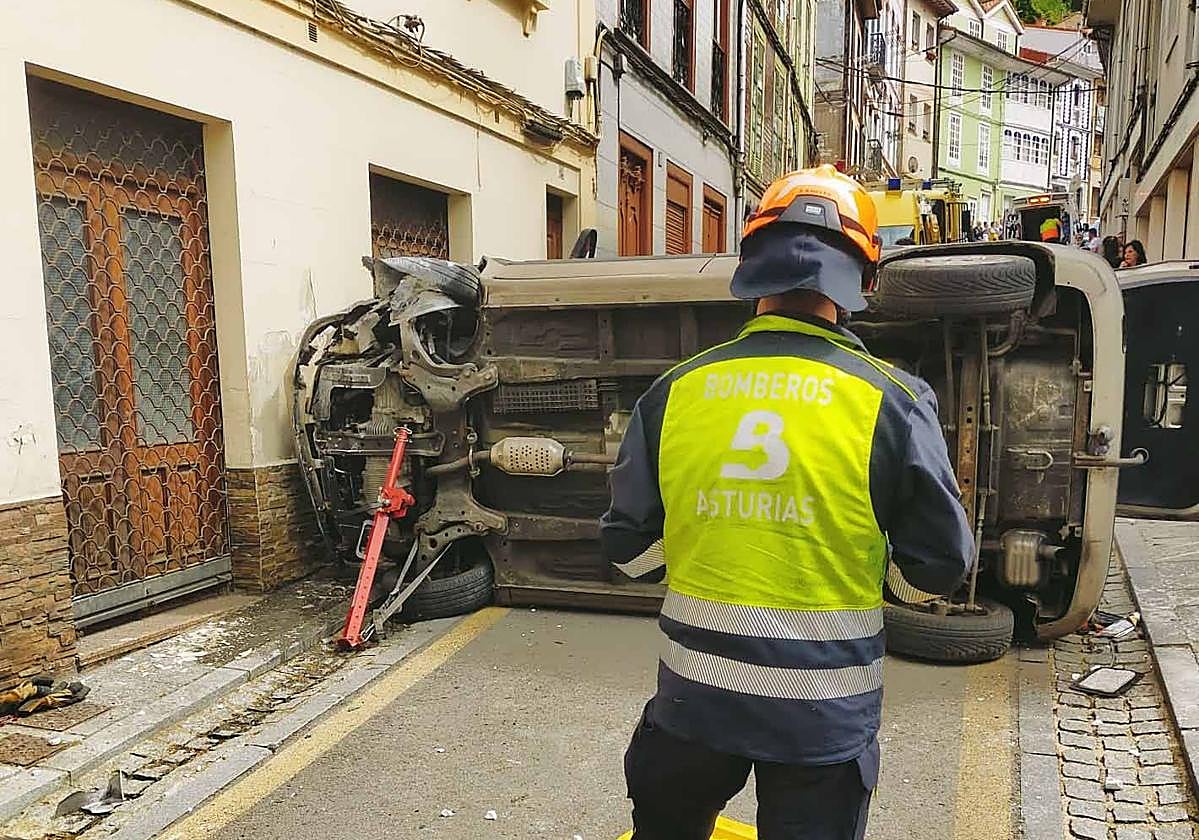 Un bombero, frente al vehículo accidentado.
