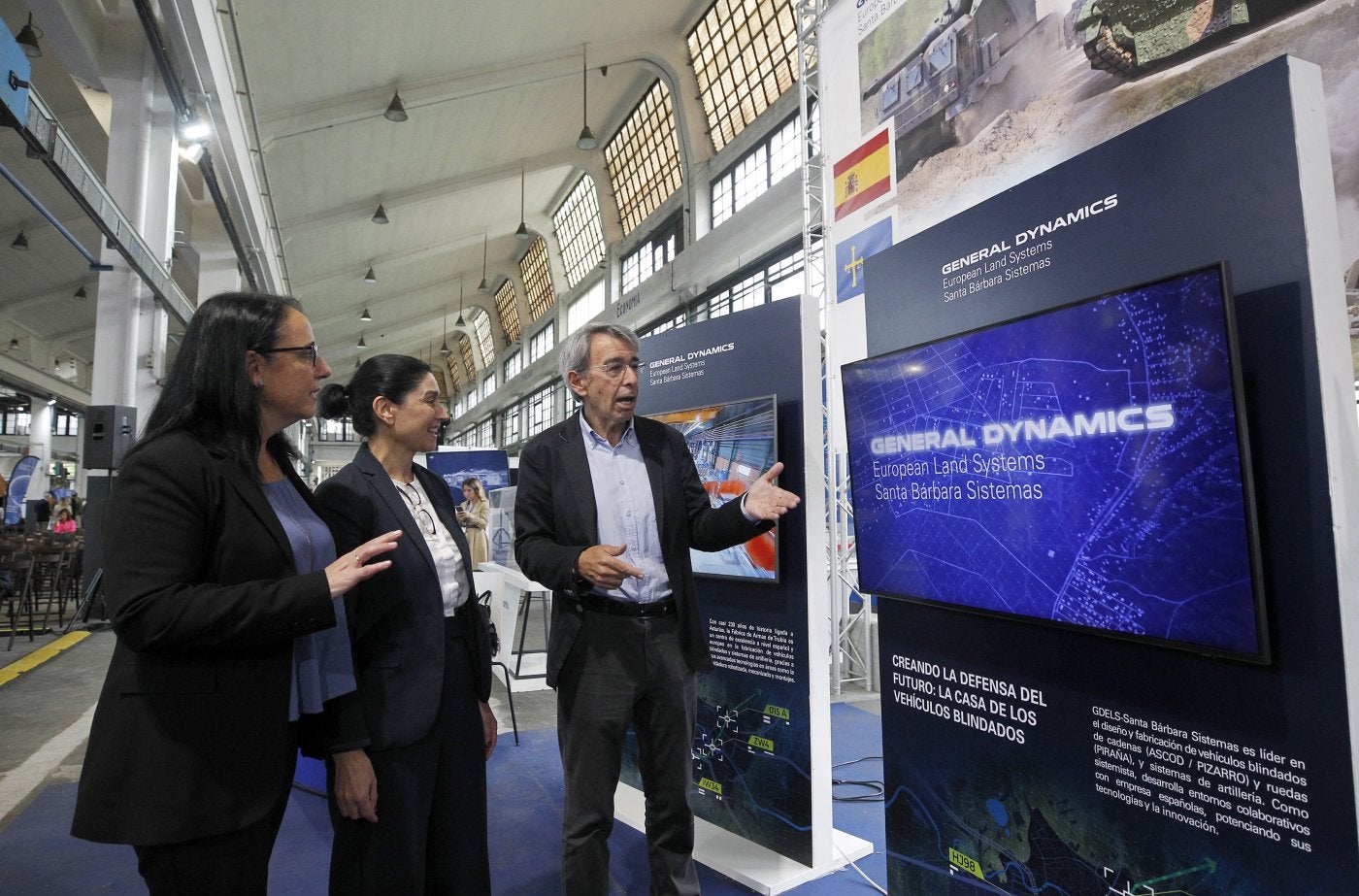 Rosa de los Santos, Raquel Fernández y Sergio Menéndez, en el estand de Santa Bárbara Sistemas. Pedro Fuster, de Indra, charla con Juan Escriña, de Santa Bárbara.