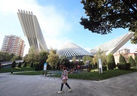 Una mujer pasea por delante del parque frente al el edificio Calatrava, cerrado desde 2019.