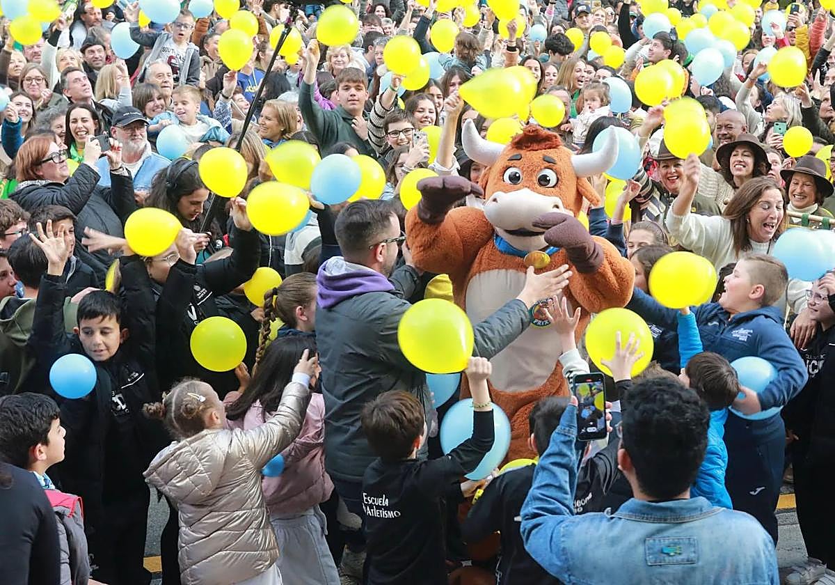 La mascota del 'Grand Prix' rodeada de vecinos de Cangas de Onís.