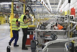 Personal técnico realizando ajustes en las instalaciones del centro logístico de Amazon.