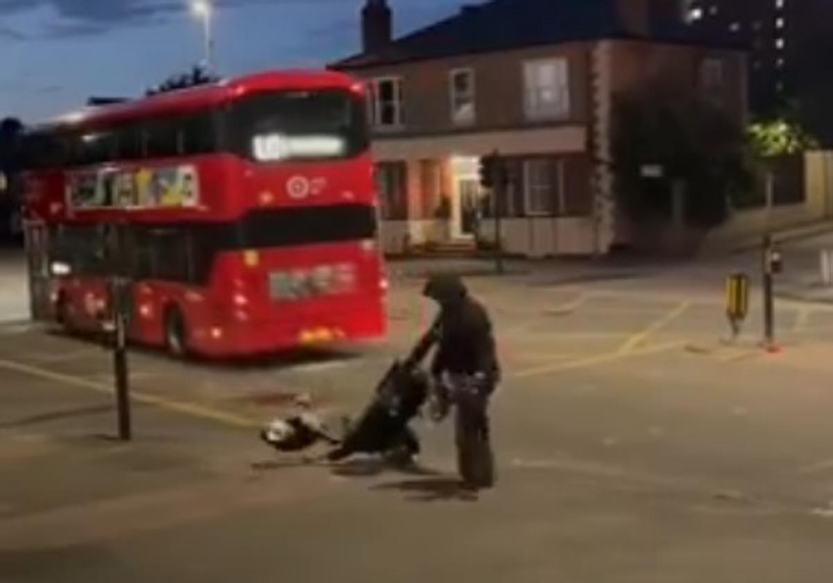 Una persona corta el poste que sujeta la cámara al paso de un autobús urbano.