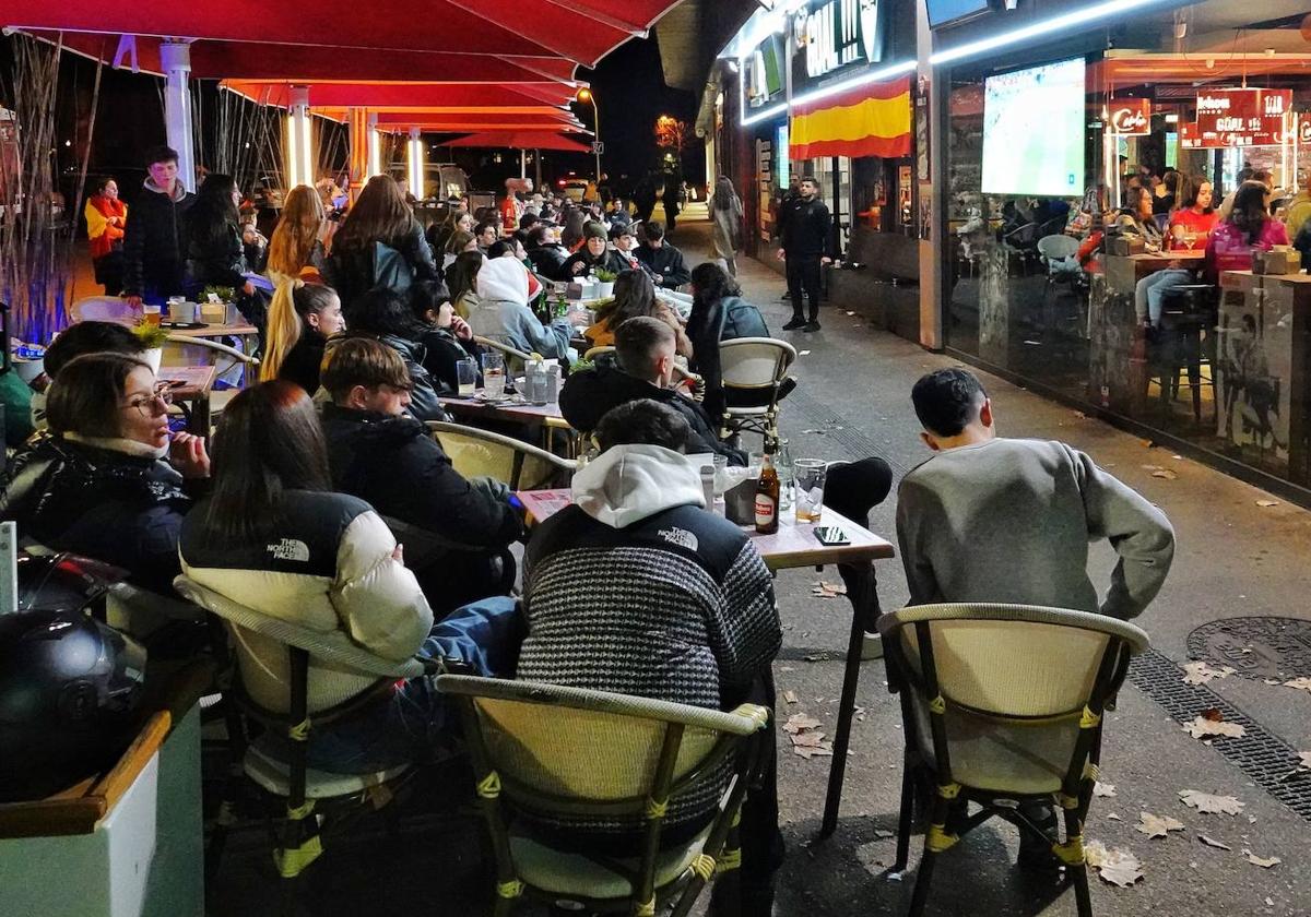 Aficionados españoles siguen un partido de España en los bajos de El Molinón.