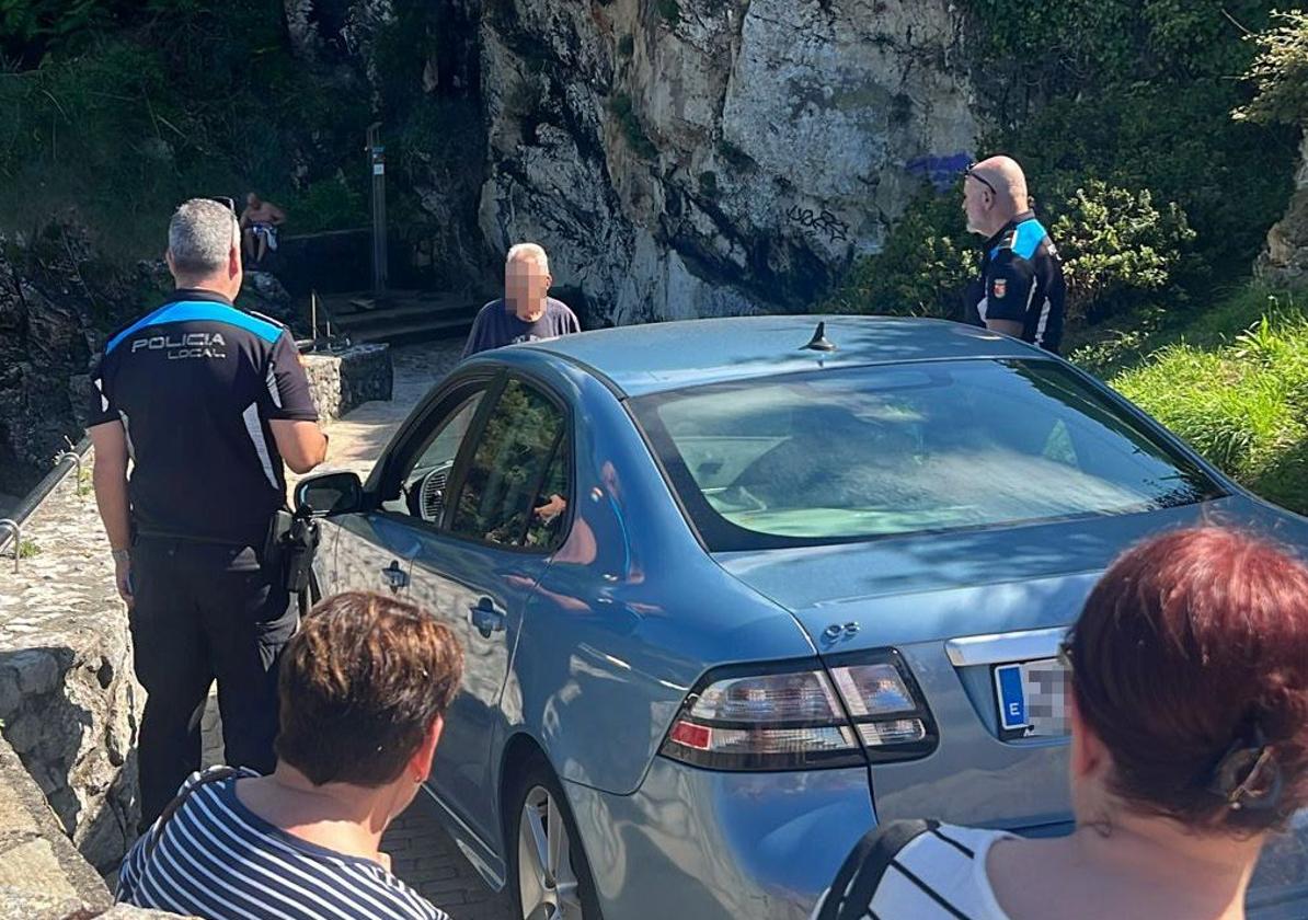 Agentes de la Policía Local de Llanes, junto al coche atrapado.