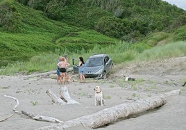 Los turistas, pidiendo ayuda para sacar su coche de la arena en el Playón de Bayas.