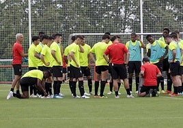 El cuerpo técnico da instrucciones a los jugadores al inicio de la sesión matinal de entrenamiento de ayer.